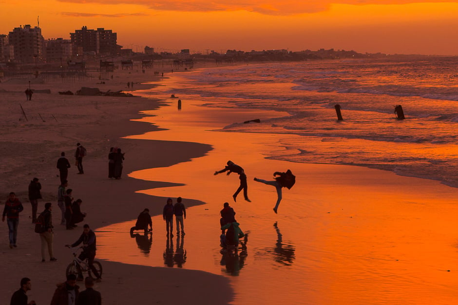 Palestinians make jumps on the beach during the sunset in Gaza City. PHOTO: AFP
