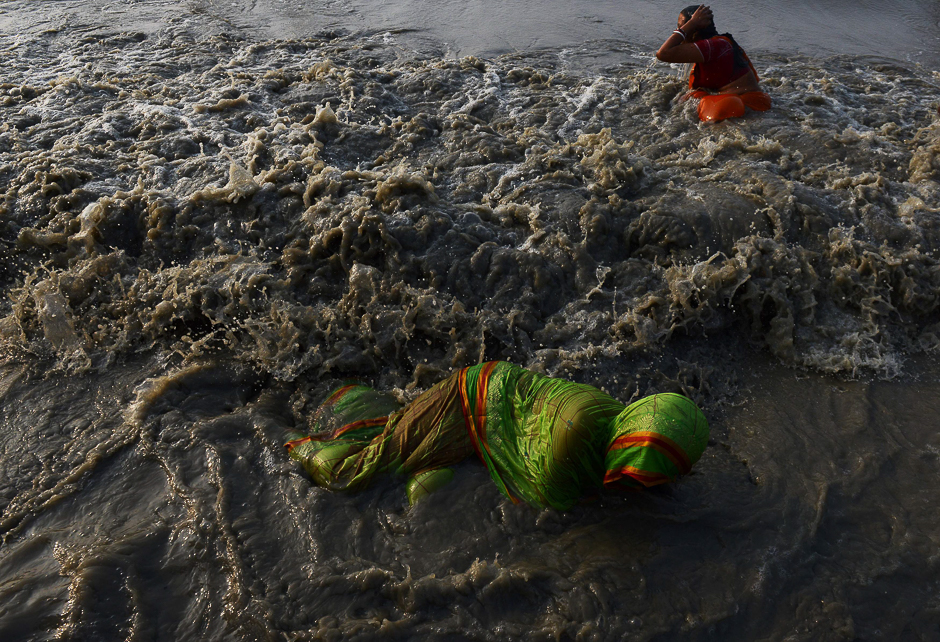 Indian Hindu devotees take a holy bath in the Bay of Bengal at the mouth of the river Ganges in Sagar Island, around 150 km south of Kolkata, PHOTO: AFP