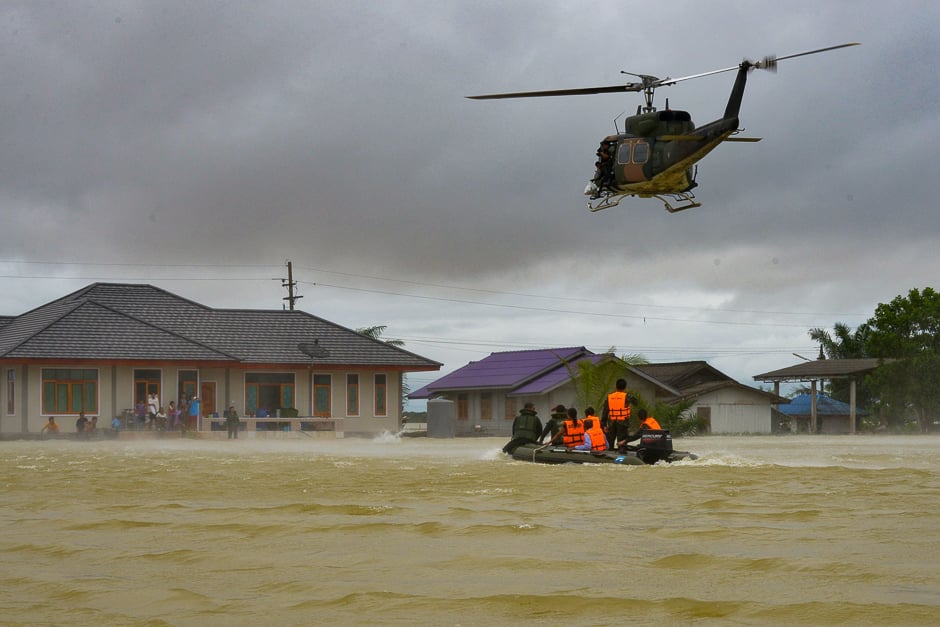 This photo shows a rescue boat and a helicopter moving towards a group of stranded people in the Srinakarin district of the southern Thai province of Phattalung. PHOTO: AFP