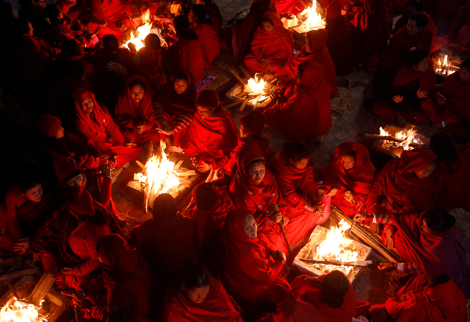 Hindu women sit around fires to keep warm before taking holy baths at Saali River during the Swasthani Brata Katha festival at Sankhu in Kathmandu, Nepal. PHOTO: REUTERS