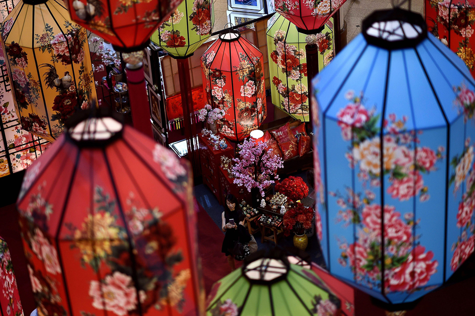 A shopper takes photographs of Chinese lantern decorations at a shopping mall in Kuala Lumpur. PHOTO: AFP