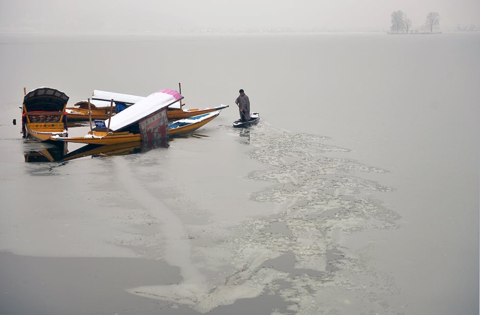 A Kashmiri boatman uses his oar to break the ice layer of the frozen Dal Lake after a heavy snowfall in Srinagar. PHOTO: AFP