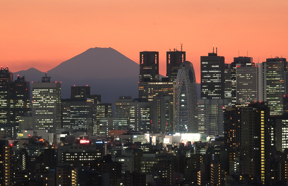 Mount Fuji, Japan's highest mountain at 3,776 metres (12,388 feet) is seen behind skyscrapers in Tokyo's Shinjuku area during sunset. PHOTO: REUTERS