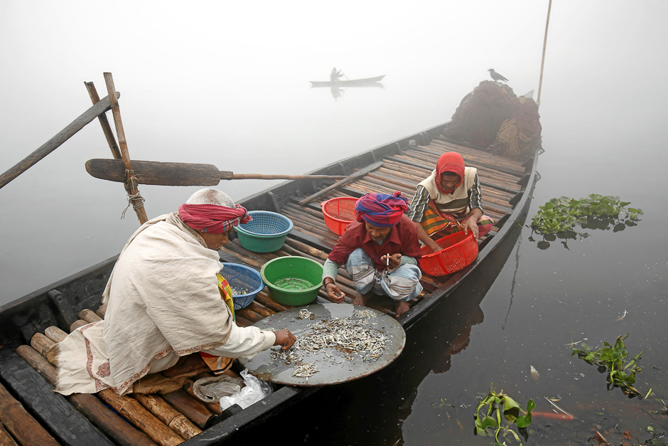 Fishermen sort out small fish which they have caught on a winter morning at the Buriganga River in Dhaka, Bangladesh. PHOTO: REUTERS