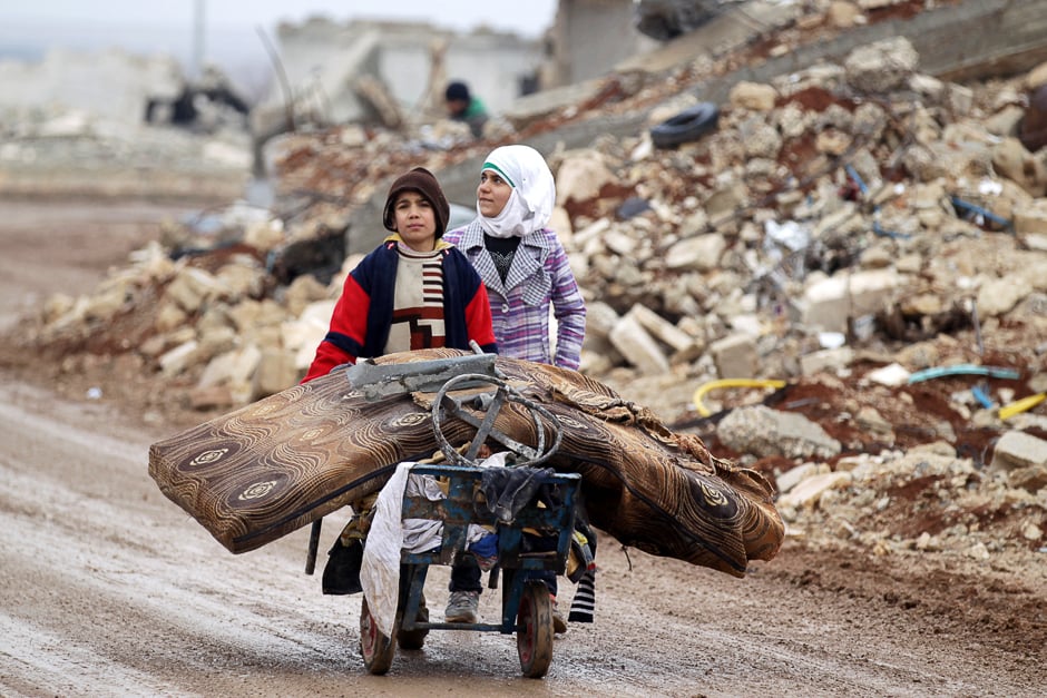 Samah, 11, and her brother, Ibrahim, transport their salvaged belongings from their damaged house in Doudyan village in northern Aleppo Governorate, Syria. PHOTO: REUTERS