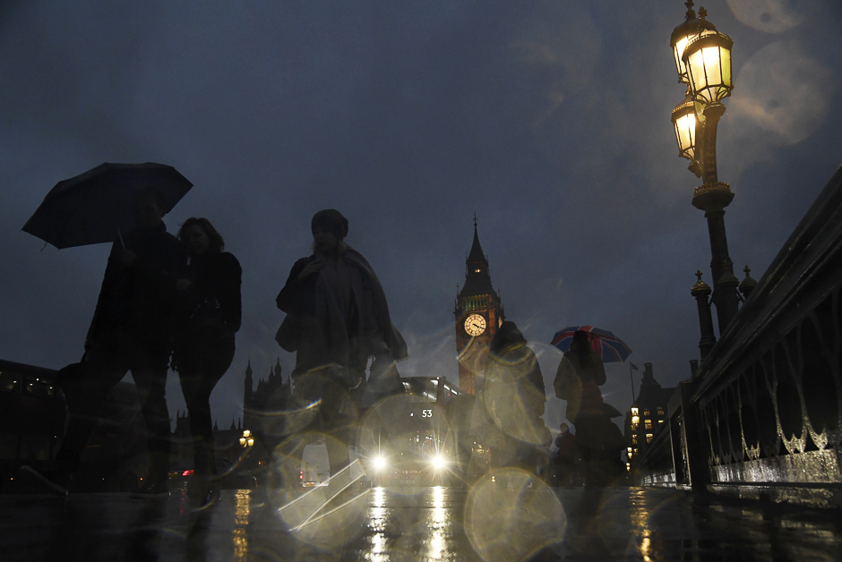 Commuters walk over over Westminster Bridge in the rain during a strike on the Underground by members of two unions in protest at ticket office closures and reduced staffing levels, in London, Britain. PHOTO: REUTERS