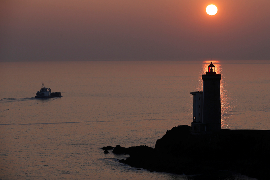 A boat makes his way behind the Phare du Petit Minou as the sun sets over the Atlantic Ocean on a cold winter day in Plouzane, France. PHOTO: REUTERS