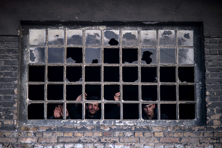 Migrants look out from a window at a makeshift shelter at an abandoned warehouse in Belgrade on with temperatures just 2.Migrants look out from a window at a makeshift shelter at an abandoned warehouse in Belgrade on with temperatures just bellow zero Celsius overnight. PHOTO: AFP zero Celsius overnight. PHOTO: AFP