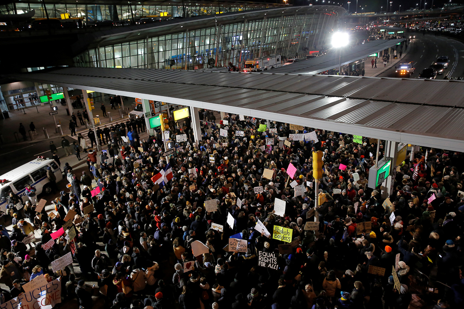 People participate in a protest against Donald Trump's travel ban outside Terminal 4 at John F. Kennedy International Airport in Queens, New York, US.PHOTO: REUTERS