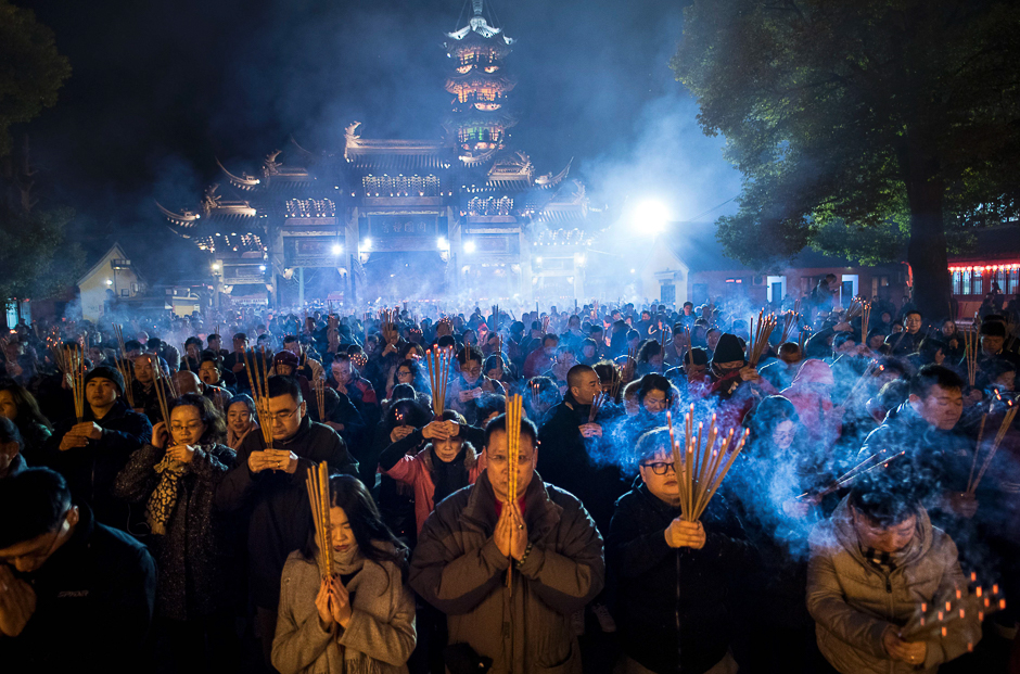 People pray with incence sticks at the Longhua temple in Shanghai. PHOTO: AFP