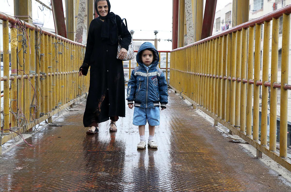 A child enjoys cold weather with his mother during rain in the port city. PHOTO: ONLINE/SABIR MAZHAR