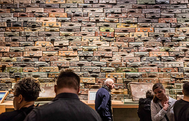 People look at piled up suitcases on January 29, 2017 as part of the permanent exhibition of Museum of Second World War opend for two days ahead the offical opening planned for the end of February in Gdansk, Poland.  Poles on Sunday got their first -- and possibly last -- glimpse of a new Museum of the Second World War, a project slammed by Poland's right-wing government as underplaying the country's harrowing wartime fate. PHOTO: AFP
