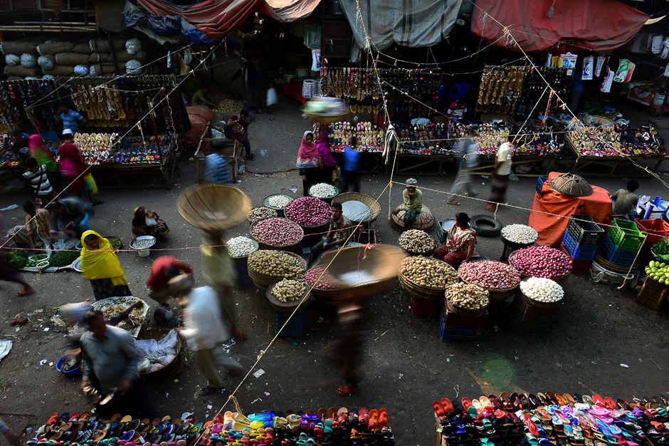 Bangladeshi vegetable vendors wait for customers at a wholesale market in Dhaka. PHOTO: AFP