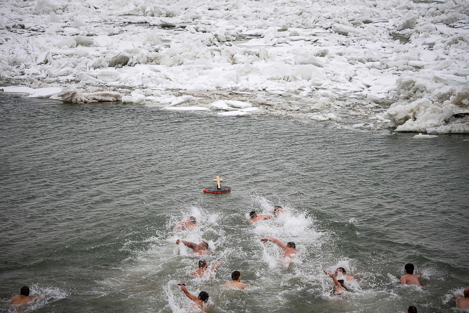 Christian Orthodox believers swim to retrieve a cross from the cold waters of the Danube River on the Orthodox Epiphany day. PHOTO: AFP