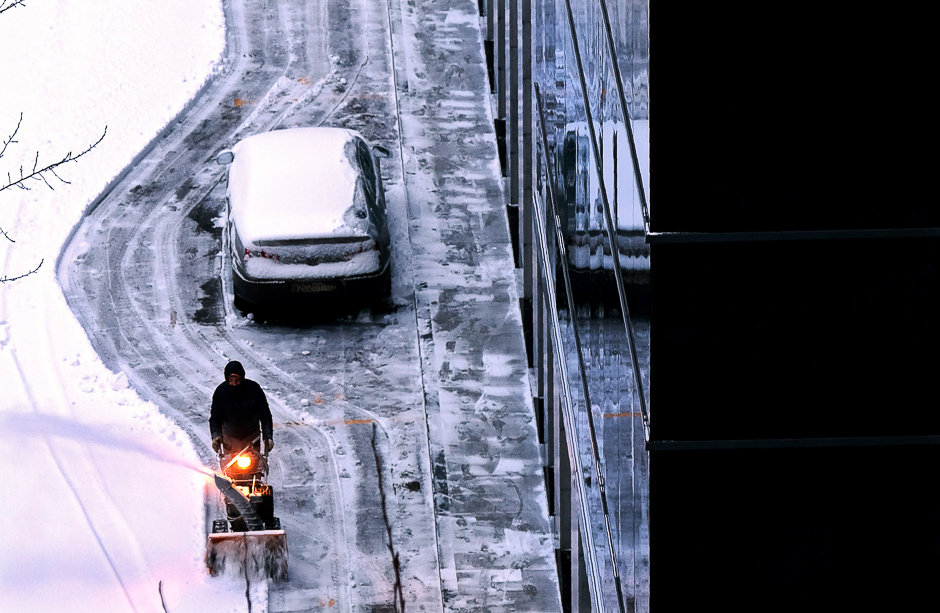 A man removes snow next to an office building following heavy snowfall in Moscow. PHOTO: AFP