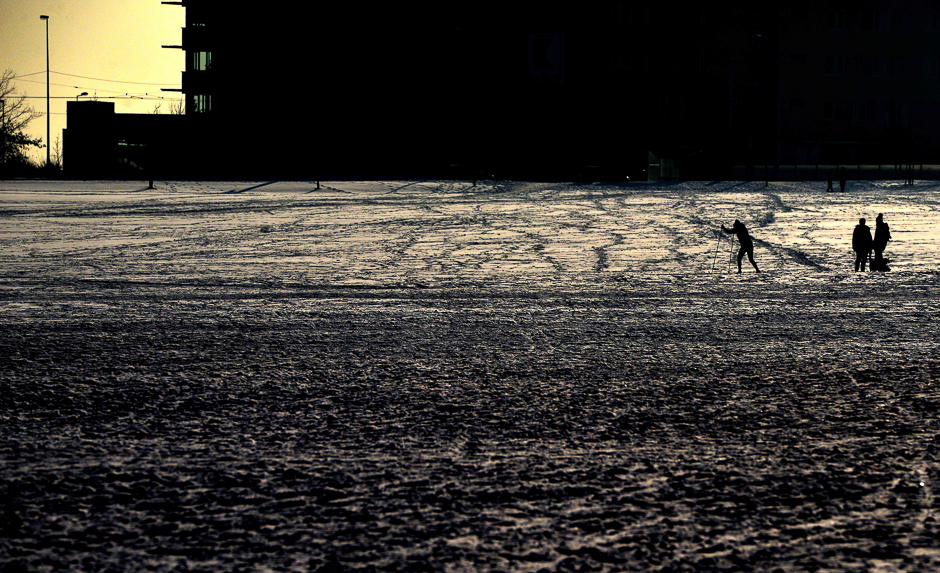 A man walks on ski across a park during a winter sunny day. PHOTO: AFP