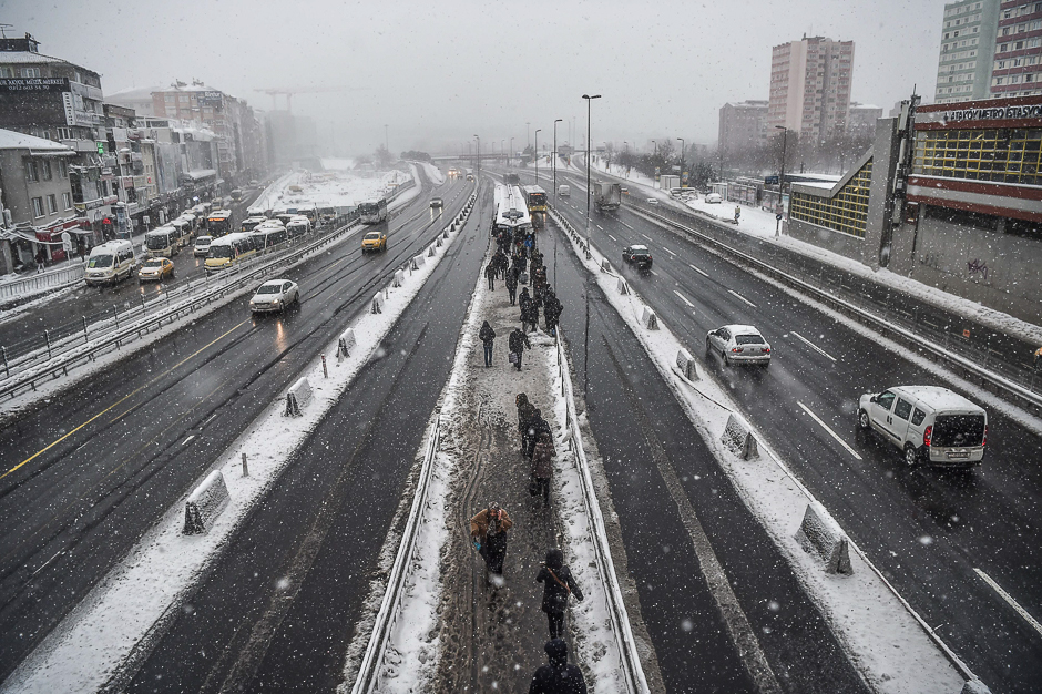 People walk at a Metrobus station during snowfalls in Istanbul. PHOTO: AFP