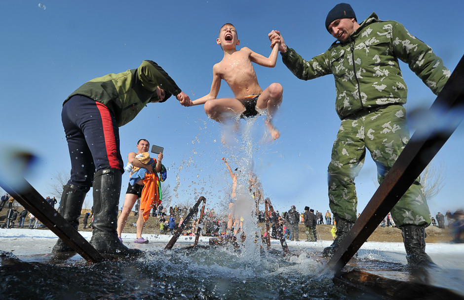 Cossacks help a boy to take a bath in the icy waters of a lake during the celebration of the Epiphany holiday near the village of Leninskoe, some 15 km of Bishkek. PHOTO: AFP