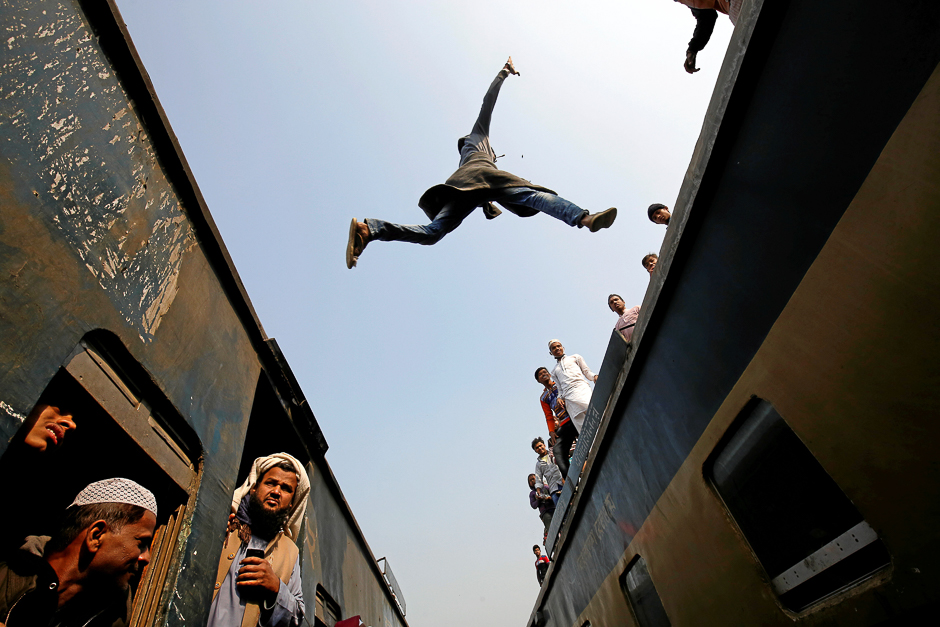 A commuter jumps between trains upon arrival at a station, to attend Akheri Munajat, the final supplication during Biswa Ijtema in Tongi, on the outskirts of Dhaka. PHOTO: REUTERS