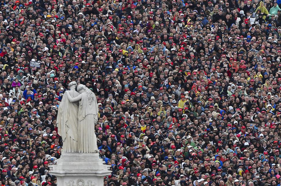 People look on and listen as President Trump delivers his inaugural address. PHOTO: REUTERS 