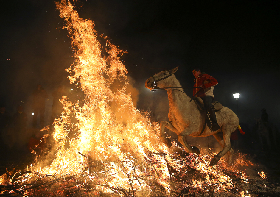 A man rides a horse through flames during the annual 