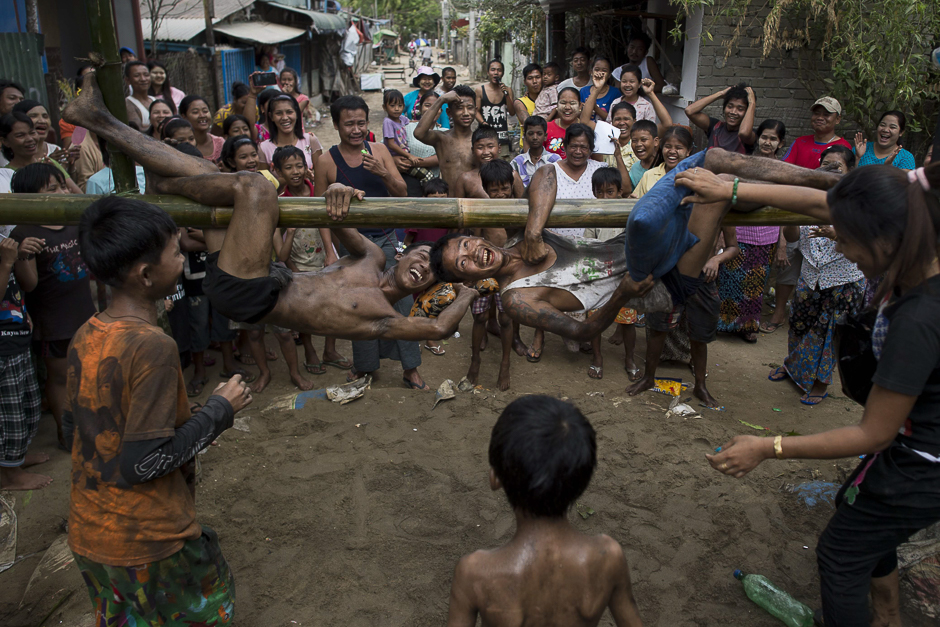Youths play a traditional pillow fight game on a bamboo pole during festivities marking the 69th anniversary of Myanmar Independence Day on the outskirts of Yangon. PHOTO: AFP