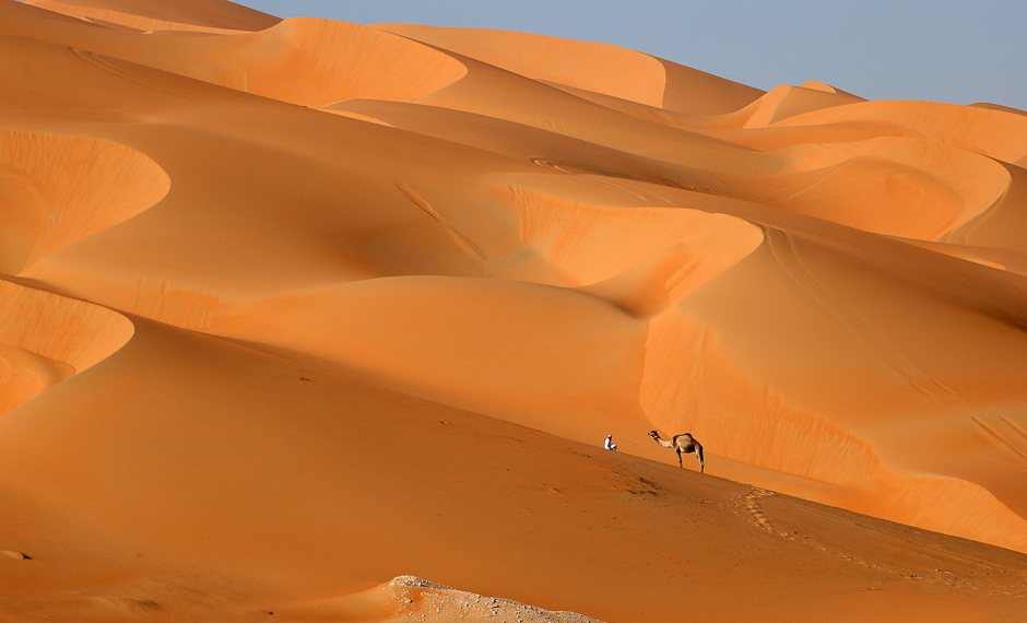 A man walks with his camel across the Liwa desert, some 250 kilometres west of the Gulf emirate of Abu Dhabi, during the Liwa 2017 Moreeb Dune Festival. PHOTO: AFP 