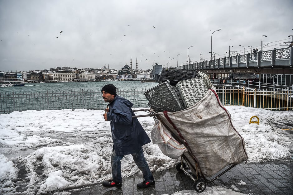 A trash collector walks next to the Galata bridge in Karakoy district after a snowfall in Istanbul on January. PHOTO: AFP