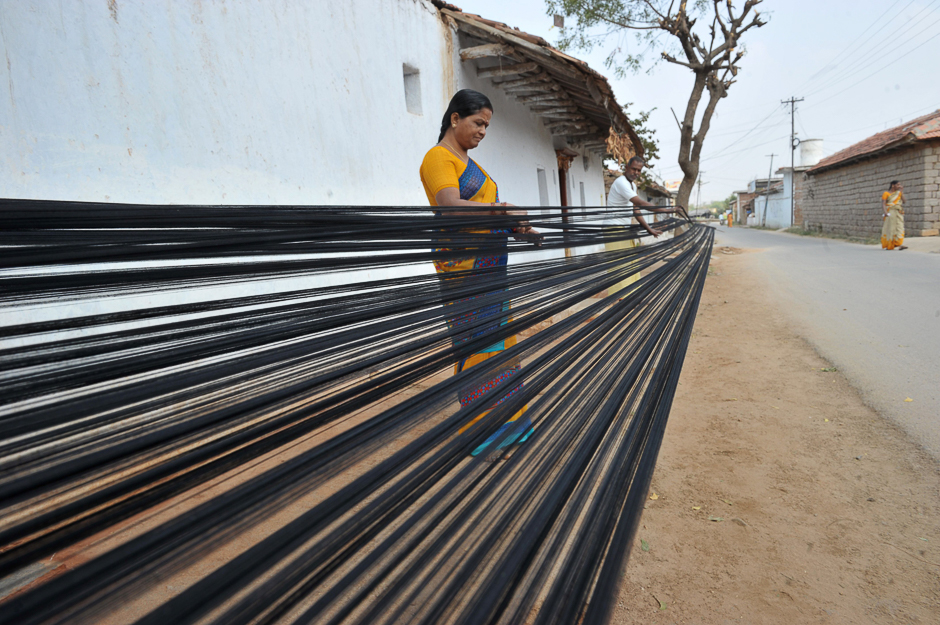 Indian weavers apply natural adhesives to the yarn, known as street sizing, at their household workshop at Koyalagudem village of Nalgonda District, some 50 kilometres from Hyderabad. PHOTO: AFP