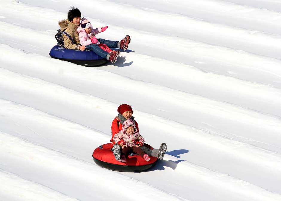 People on a tube ride a slide covered with snow during the Ice and Snow carnival at Taoranting Park in Beijing, China. PHOTO: REUTERS