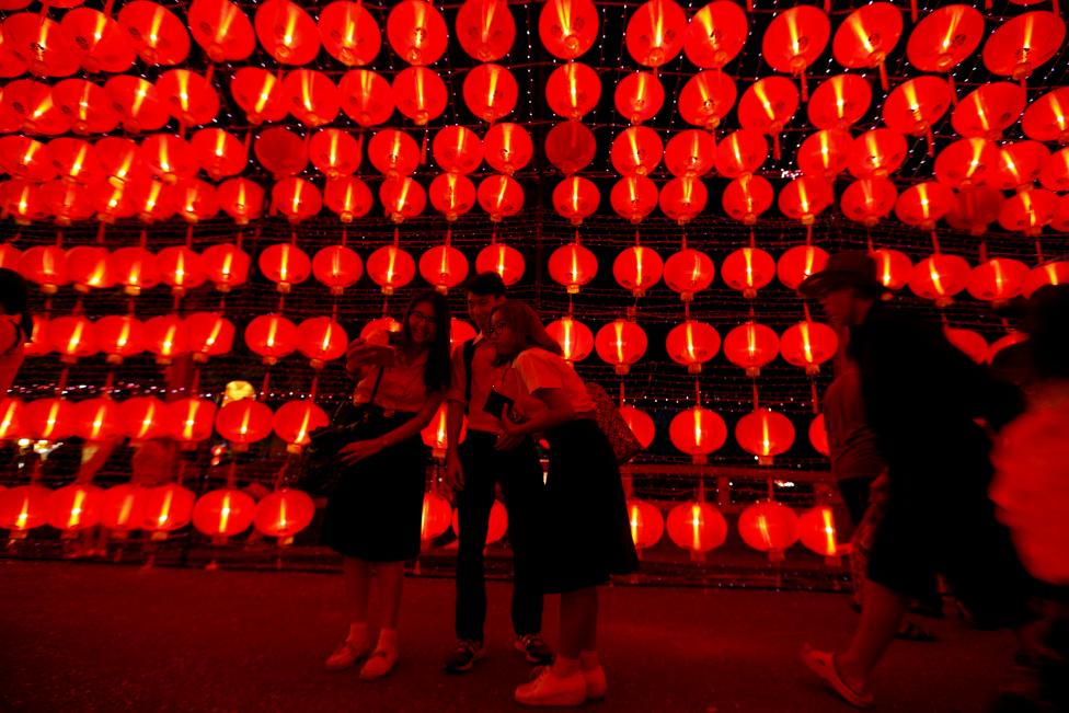 People walk on a street decorated with Chinese lamps to celebrate the Lunar New Year in Bangkok, Thailand. REUTERS/Jorge Silva
