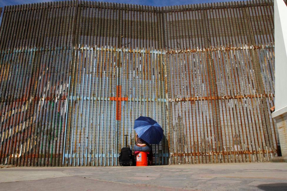 MEXICO: A woman talks to her relatives across a fence separating Mexico and the United States, in Tijuana, Mexico, November 12, 2016. REUTERS/Jorge Duenes