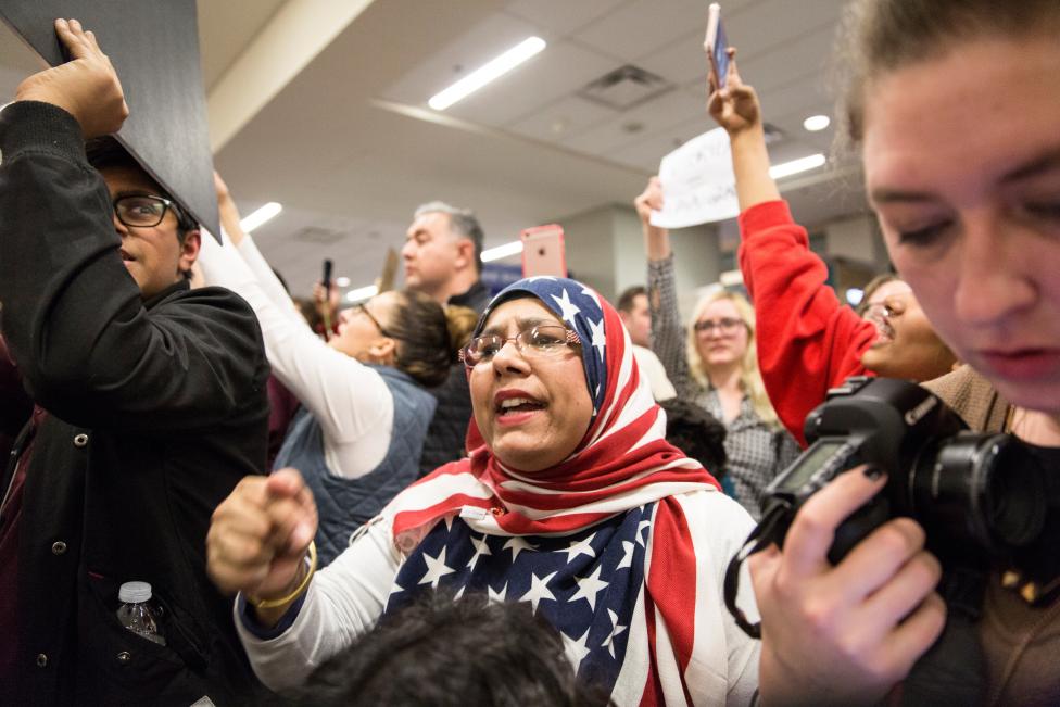 A woman in an American flag hijab chants with other protesters against the travel ban imposed by U.S. President Donald Trump's executive order, at Dallas/Fort Worth International Airport in Dallas. REUTERS/Laura Buckman
