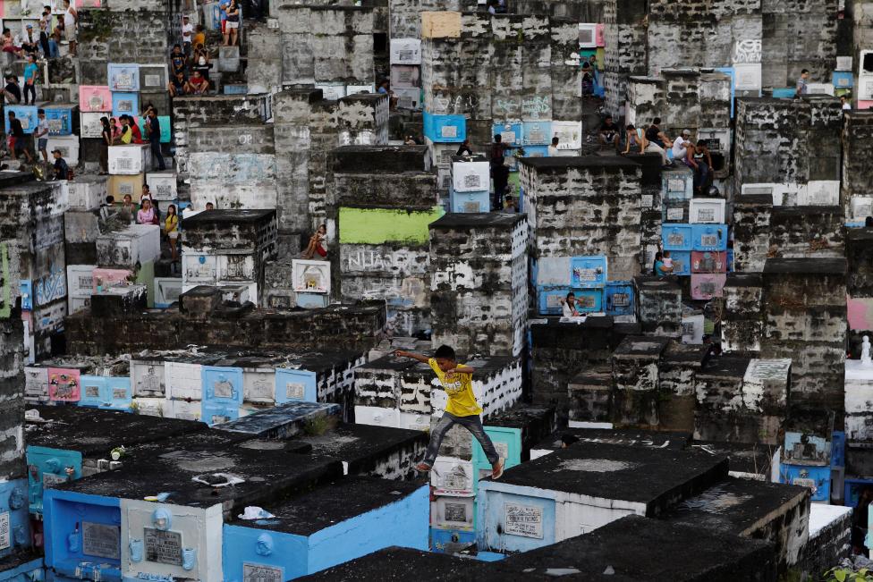 PHILIPPINES: A boy leaps in-between apartment-style tombs as Filipinos visit the graves of their deceased loved ones to commemorate All Saints Day, at Barangka public cemetery in Marikina city, Metro Manila, Philippines November 1, 2016. REUTERS/Czar Dancel