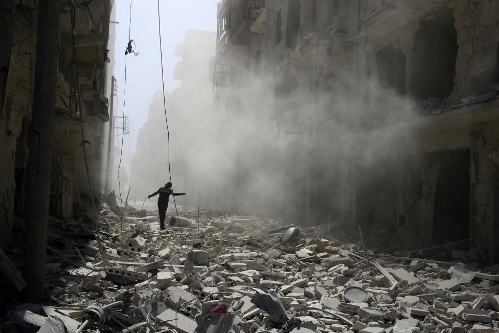SYRIA: A man walks on the rubble of damaged buildings after an airstrike on the rebel held al-Qaterji neighbourhood of Aleppo, Syria September 25, 2016. REUTERS/Abdalrhman Ismail