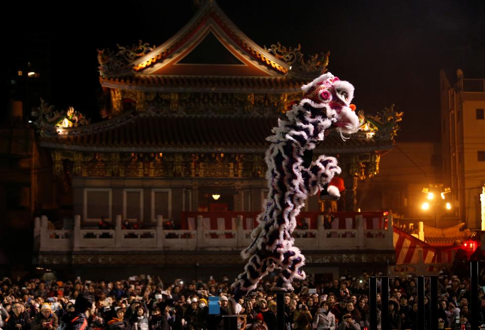 Dancers perform a lion dance in front of a temple as they celebrate the Lunar New Year in China Town, in Yokohama, south of Tokyo, Japan. REUTERS/Kim Kyung-Hoon