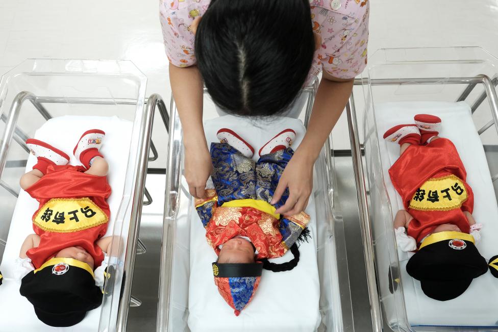 A nurse takes care of newborn babies wearing Chinese traditional costumes to celebrate the Chinese New Year at the nursery room of Paolo Chockchai 4 Hospital, in Bangkok, Thailand. REUTERS/Athit Perawongmetha