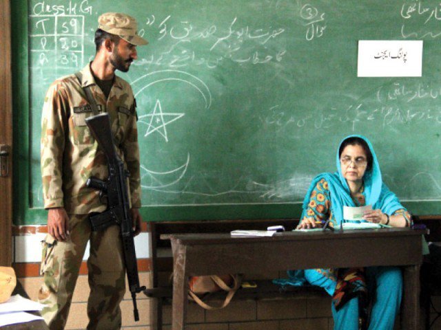 In this file photo, a Pakistan Army soldier stands guard as a presiding officer in NA-254 Korangi, Karachi. PHOTO: EXPRESS