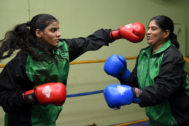 in this photograph taken on october 6 2016 19 year old pakistani boxer razia banu l throws a punch at her mother haleema abdul aziz during a practice session at the pak shaheen boxing club in karachi photo afp