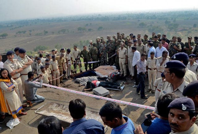 police officers and special task force soldiers stand beside dead bodies of the suspected members of the banned students islamic movement of india simi who earlier today escaped the high security jail in bhopal and later got killed in an encounter at the acharpura outside bhopal photo reuters