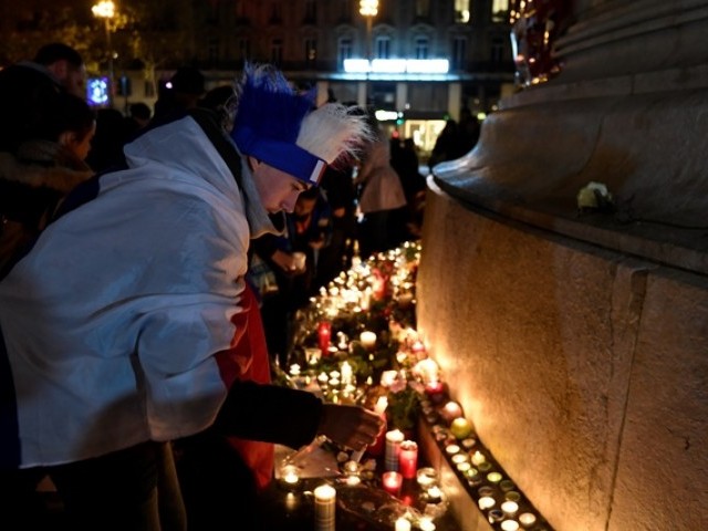 A man lights a candle at a makeshift memorial near the Bataclan concert hall in Paris on November 13, 2016 as France marked the first anniversary of the Paris attacks with sombre ceremonies and painful memories for the relatives of the 130 people killed. PHOTO: AFP