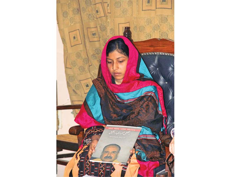 hani baloch holds a photograph of her missing father and urges the government to help recover him soon photo ayesha mir express