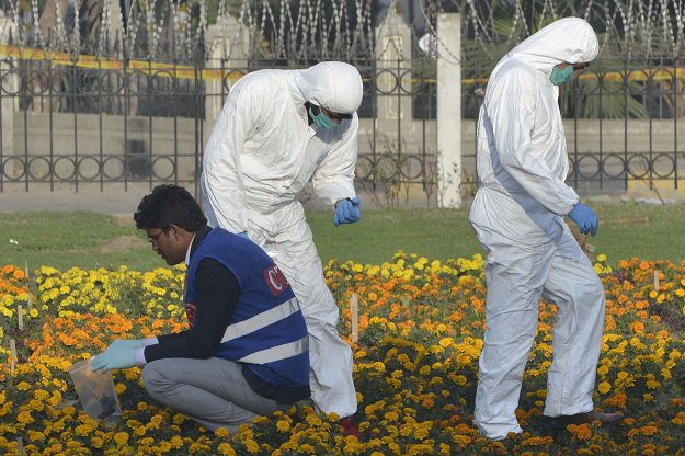 Security officials collect evidence at the site of a suicide bombing in Lahore on February 14, 2017. PHOTO: AFP