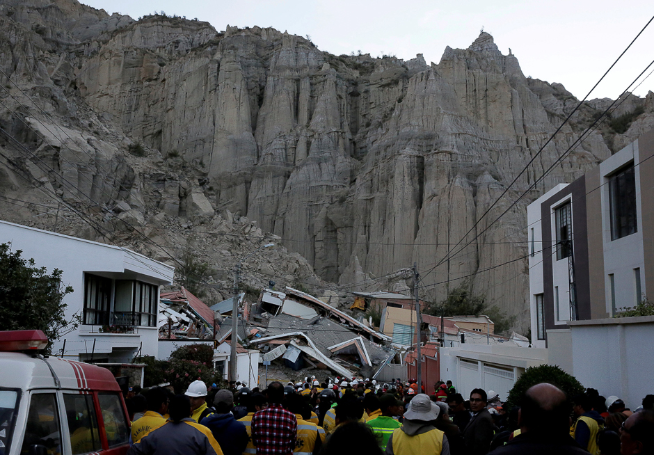 People and rescue team members gather by buildings which collapsed following a landslide in Auquisamana district in La Paz, Bolivia. PHOTO: REUTERS