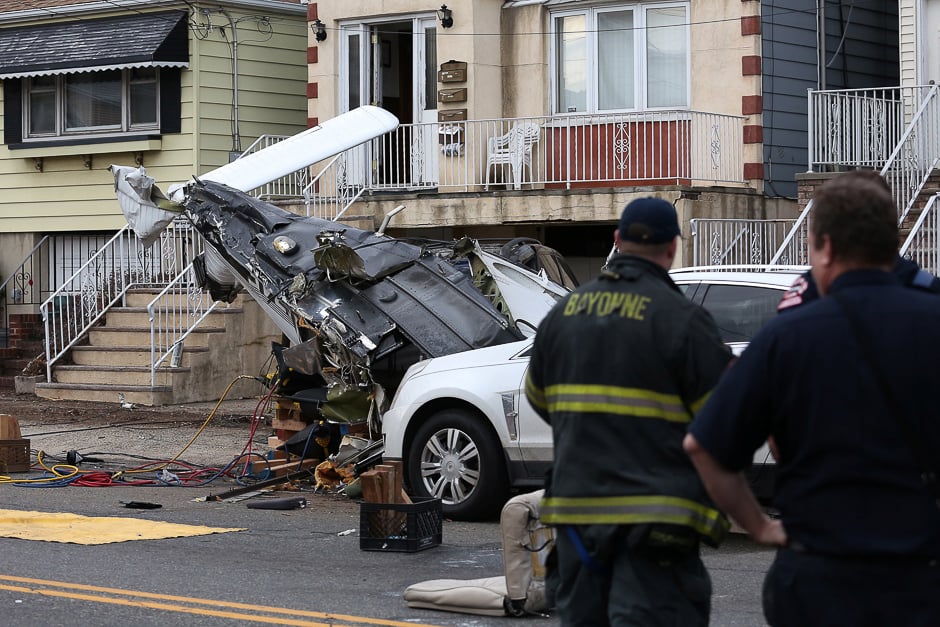 Officials survey the scene where a small plane crash landed on a residential street in Bayonne, New Jersey, US. PHOTO: REUTERS