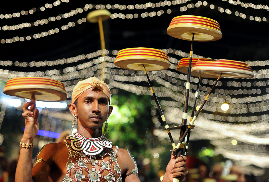 Traditional dancers and musicians perform in a procession in front of the Gangarama Temple. PHOTO: AFP