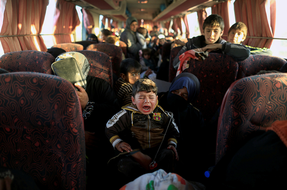 A boy, who just fled a village controlled by Islamic State fighters cries as he sits with his family inside a bus before heading to the camp at Hammam Ali south of Mosul, Iraq. PHOTO: REUTERS