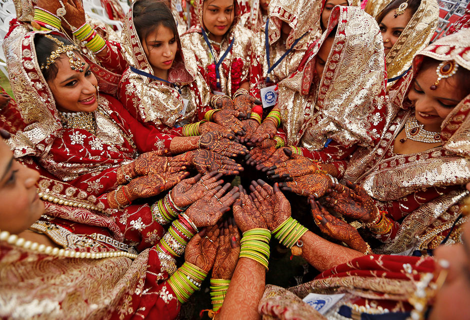 Brides pose as they display their hands decorated with henna before taking their wedding vows during a mass marriage ceremony in which, according to its organisers, 131 Muslim couples took their wedding vows in Ahmedabad, India. PHOTO: REUTERS