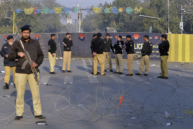 Policemen gather at the site of a suicide bombing in Lahore on February 14, 2017. PHOTO: AFP