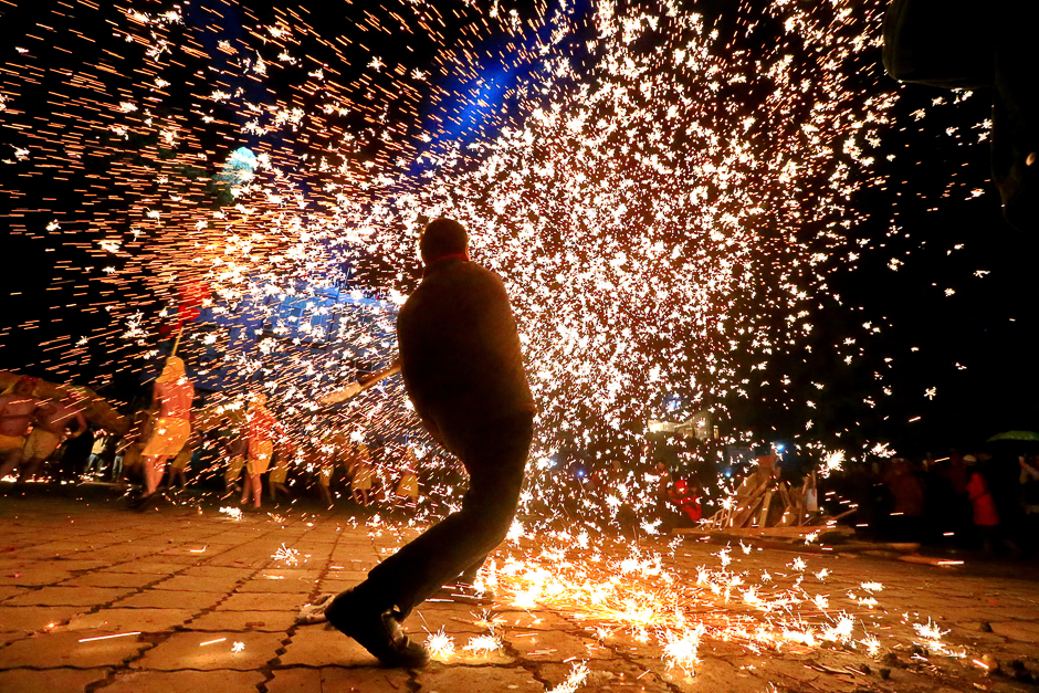 A folk artist makes sparks as performers perform a fire dragon dances with the shower of melted iron spark on Lantern Festival in Suining, Sichuan province. PHOTO: REUTERS